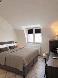 a bedroom with a large bed and a window at B&B Saint Pierre in Maastricht