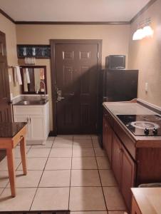 a kitchen with a black door and a tile floor at Gated 2 Double Beds Studio with Full Kitchen 134 in Baton Rouge +15 photos