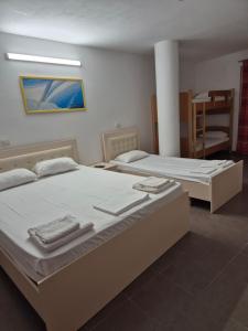 two twin beds in a room with at Rooms and Apartments Analipsi in Shëngjin