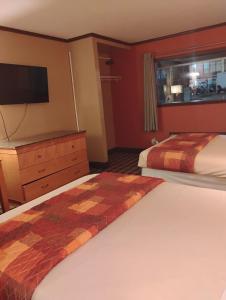 a hotel room with two beds and a tv at Gated 2 Double Beds Studio with Full Kitchen 134 in Baton Rouge
