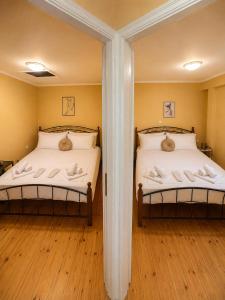 two twin beds in a room with wooden floors at Belle Elle Villa in Drymon