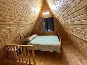 a small room with a bed in a log cabin at cottages house in Namlisevi