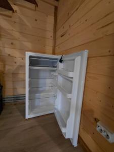 an empty refrigerator in a room with a wooden wall at Carpathian House in Krasnik