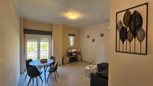 a living room with a couch and a table and chairs at Estia Chios Apartments B3 in Karfas +8 photos