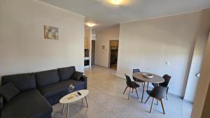 a living room with a couch and a table and chairs at Estia Chios Apartments B3 in Karfas