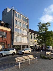 two cars parked in a parking lot in front of a building at Studio Kortrijk in Kortrijk