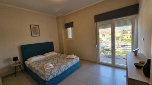 a bedroom with a bed and a sliding glass door at Estia Chios Apartments B3 in Karfas