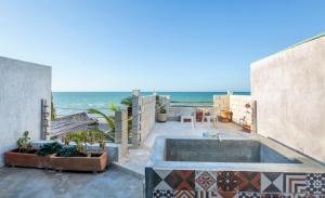 a patio with a swimming pool and the ocean at Puerto del Cielo in Chuburná