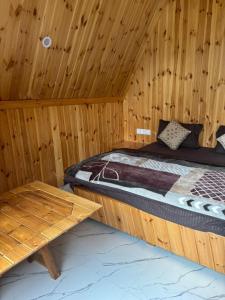 a bedroom with a bed in a wooden cabin at Clifton Chapter Cottage Tirthan in Banjār +13 photos