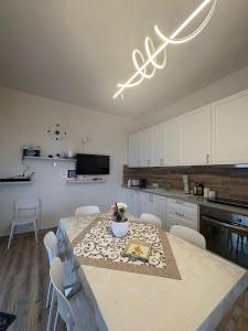 a kitchen with a table and white cabinets at Villetta della Pace nel cuore del Salento in Torre Santa Susanna
