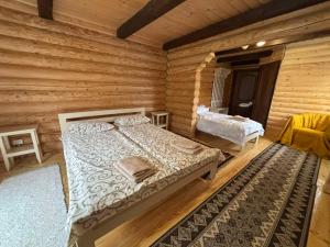 a bedroom with a bed in a log cabin at Gostynnyi Dvir u Marichky in Lazeshchyna +87 photos