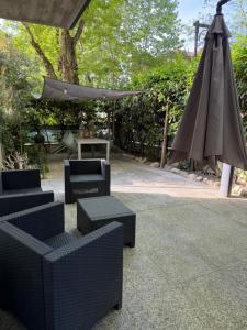 a patio with an umbrella and chairs and a table at Perla del Mare in Cesenatico