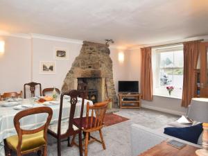 a living room with a table and a stone fireplace at 4 Bed in Bishop Auckland oc-93527 in Wear Head