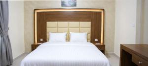 a bedroom with a large bed with a wooden headboard at تراس للشقق المخدومة in Dammam