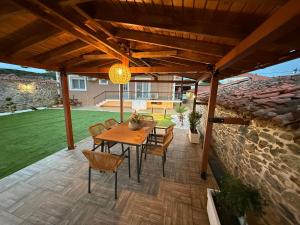 a patio with a wooden table and chairs and a stone wall at Modern Makri in Makri