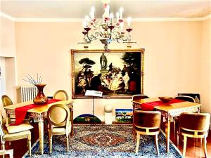 a dining room with a table and a chandelier at Boutique Hotel L'Imperatrice -Vicinissimi a Valdichiana Designer Village- in Foiano della Chiana