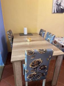 a wooden table with chairs and a candle on top at Demane-bebbih in Étouars