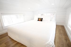 a white bed in a room with a window at River and Twine in Rocky Mount
