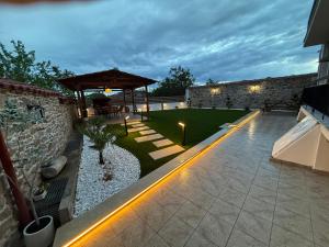 a backyard with a stone wall and a patio at Modern Makri in Makri