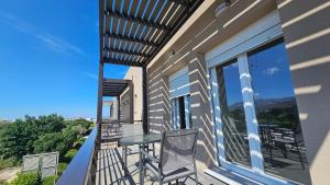 a patio with a table and chairs on a balcony at Estia Chios Apartments B3 in Karfas