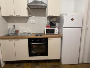 a kitchen with a white refrigerator and a microwave at Demane-bebbih in Étouars +11 photos