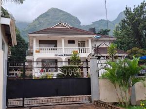 a white house with a black fence and mountains at G4 homez in Morogoro +4 photos