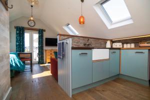 a kitchen with white cabinets and a skylight at Garden View Apartment in Salcombe