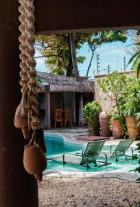 a view of a swimming pool with chairs and a house at Maly Boutique Hotel in Fortaleza