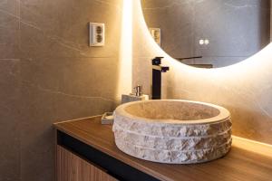 a bathroom with a stone sink and a mirror at Ponta do Sol hills view 2BR in Ponta do Sol +11 photos