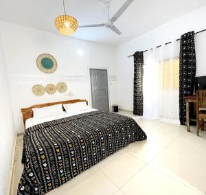 a bedroom with a bed with a black and white comforter at Hôtel villa blanca in Lomé