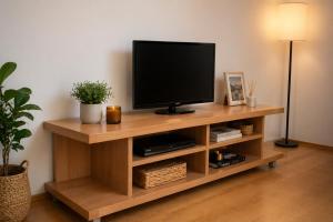 a television on a wooden stand in a living room at Livija rooms in Petrovec