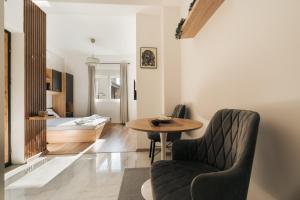 a living room with a table and a chair and a bed at Bubbles 2 Apartments in Gevgelija +7 photos
