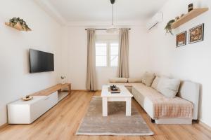 a white living room with a couch and a table at Bubbles 2 Apartments in Gevgelija