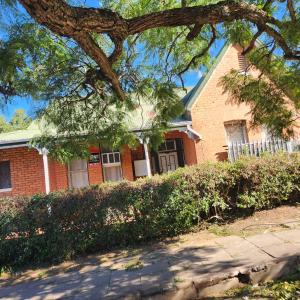 a brick house with a tree in front of it at S-and Kasa Guest House in Pietermaritzburg