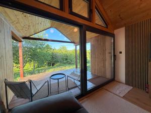 a room with a glass door and chairs and a table at Dushka Mountain Cabin in Belec