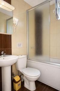 a bathroom with a toilet and a sink and a shower at Livija rooms in Petrovec +16 photos