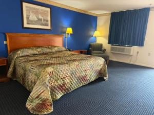 a hotel room with a bed and a chair at Wethersfield Motel in Wethersfield