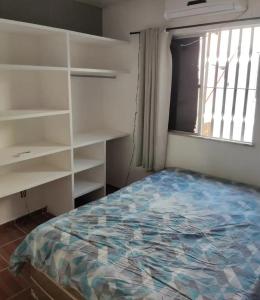a bedroom with a bed and shelves and a window at Bruno in São José de Ribamar
