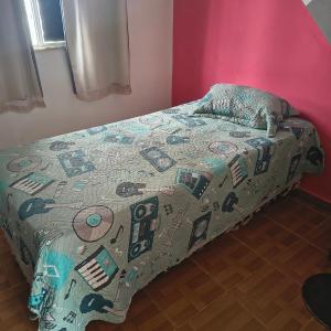 a bed with a comforter on it in a bedroom at Bruno in São José de Ribamar