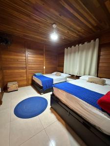 two beds in a room with wooden walls at Rancho Nosso Lago in Domingos Martins +33 photos