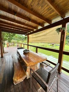a wooden table and chairs on a wooden deck at Rancho Nosso Lago in Domingos Martins