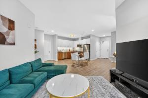 a living room with a green couch and a table at Spacious & Modern 2BR 2BA unit in assembly square in Somerville