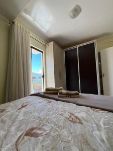 a large bed in a room with a large window at Apto no Centro de Guaíra com ar condicionado na sala e quarto in Guaíra