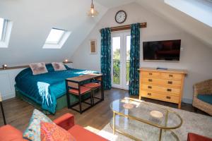 a bedroom with a bed and a desk and a tv at Garden View Apartment in Salcombe