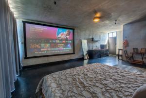 a bedroom with a large projection screen on the wall at Puerto del Cielo in Chuburná