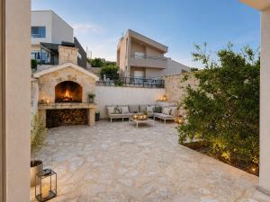 an outdoor patio with a fireplace and a couch at Villa Jasmin Posedarje in Posedarje