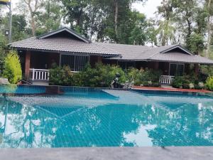 a house with a motorcycle parked next to a swimming pool at Mistora Estate Villa in Suntikoppa
