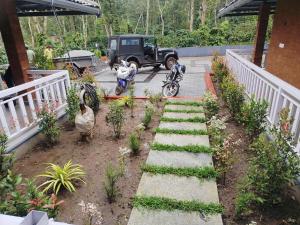 a garden with chickens and a jeep and plants at Mistora Estate Villa in Suntikoppa