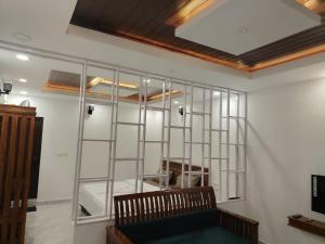 a room with a glass wall with a wooden ceiling at Mistora Estate Villa in Suntikoppa