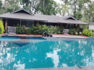 a house with a large pool of water in front of it at Mistora Estate Villa in Suntikoppa +12 photos